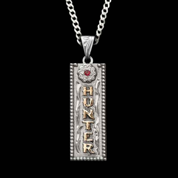 The Custom Name Tag Pendant is perfect for a special gift or your personal style! Crafted on a hand-engraved, German Silver base. Detailed with a beautiful flower and a beaded edge. Customize with your choice of lettering and color cubic zirconia stones.

